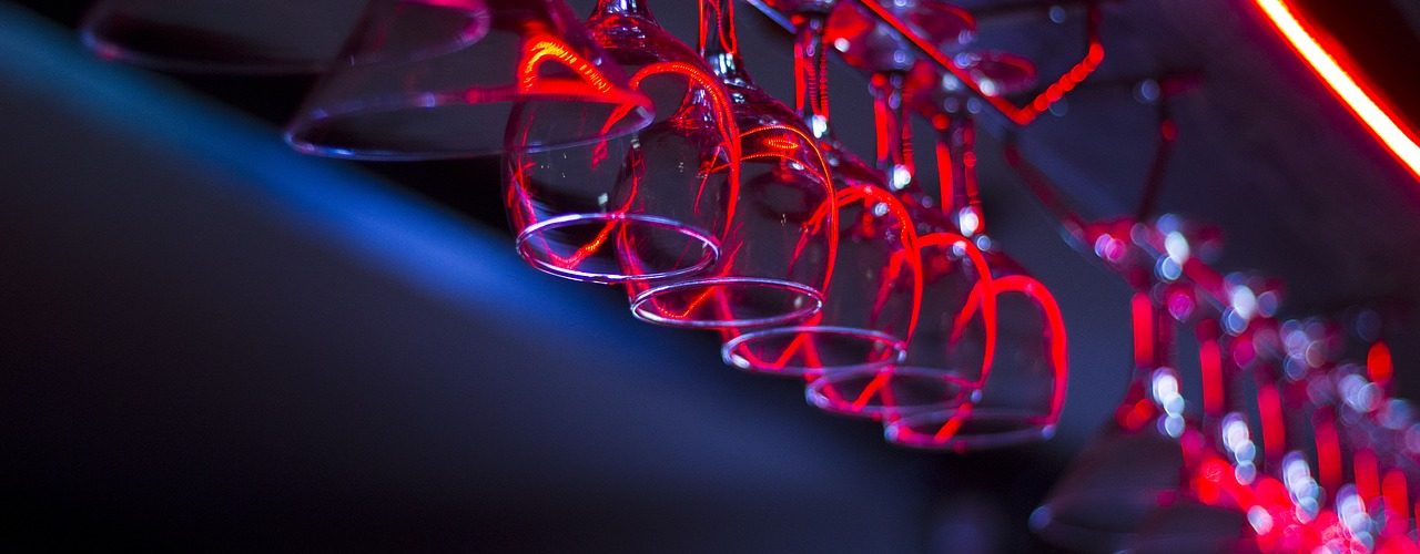 Vinglas hänger på rad i en bar.